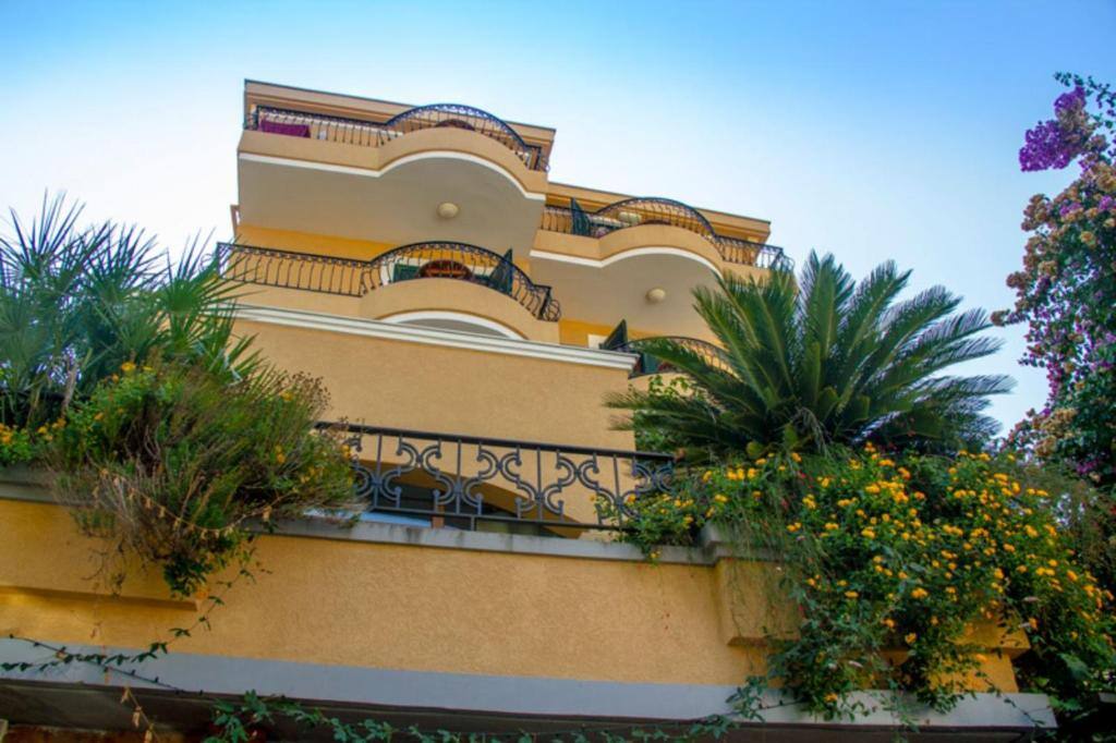 Facade of Garni Hotel Meduza with palms and flowers